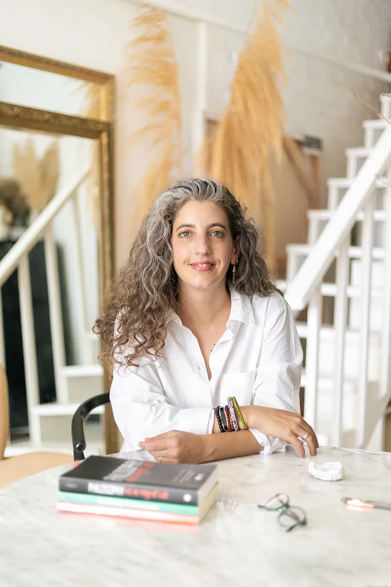 Author Dr. Emily Sadowski seated at a table with books in front of her
